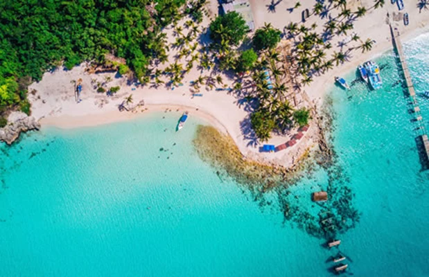 Forestill deg å våkne opp til lyden av bølger som slår forsiktig mot kritthvite sandstrender på f...